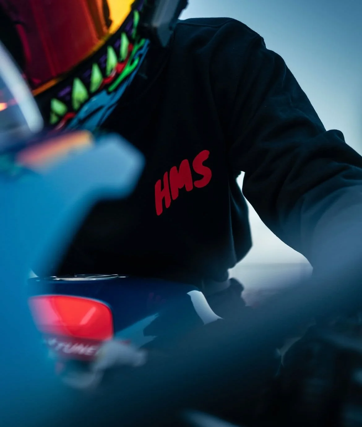 Close-up of a person wearing a black HMS jacket, with a contactless card reader in the foreground.