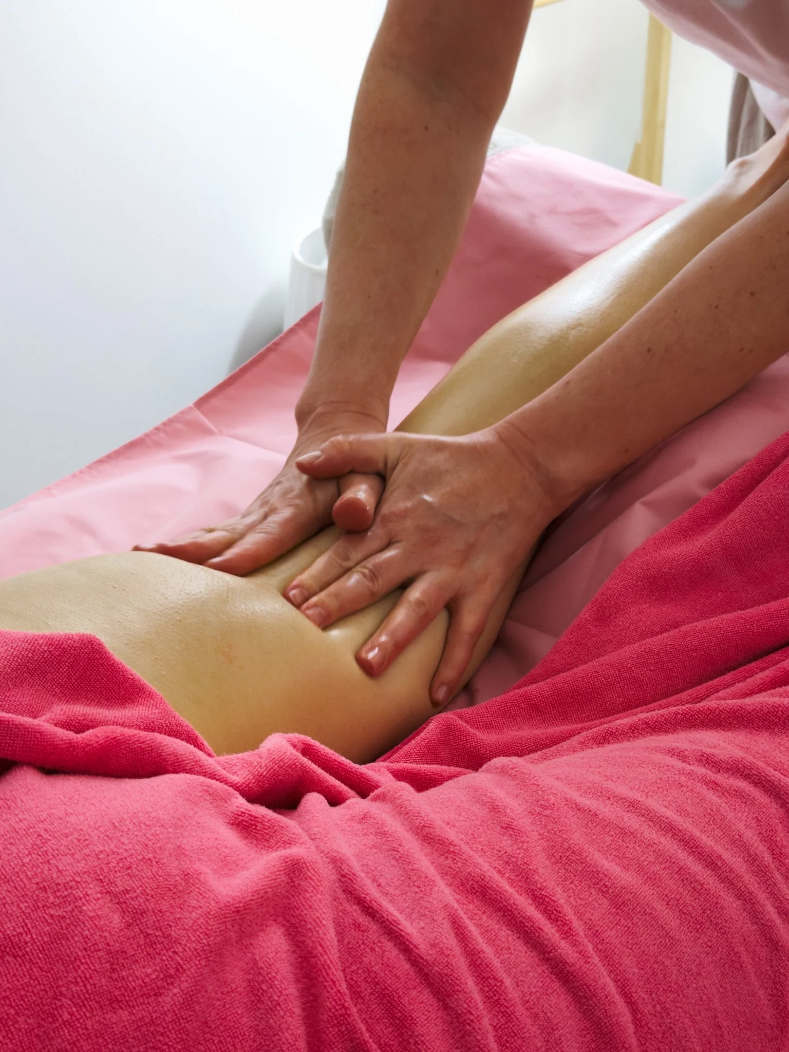 Person receiving a therapeutic leg massage at inSoul Wellness in Greenwich, using targeted techniques to ease muscle tension, support circulation and promote deep relaxation in a calming spa environment.