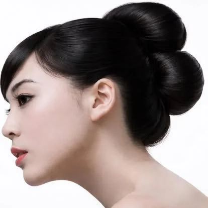Side profile of a woman with smooth black hair styled in elegant updo buns.