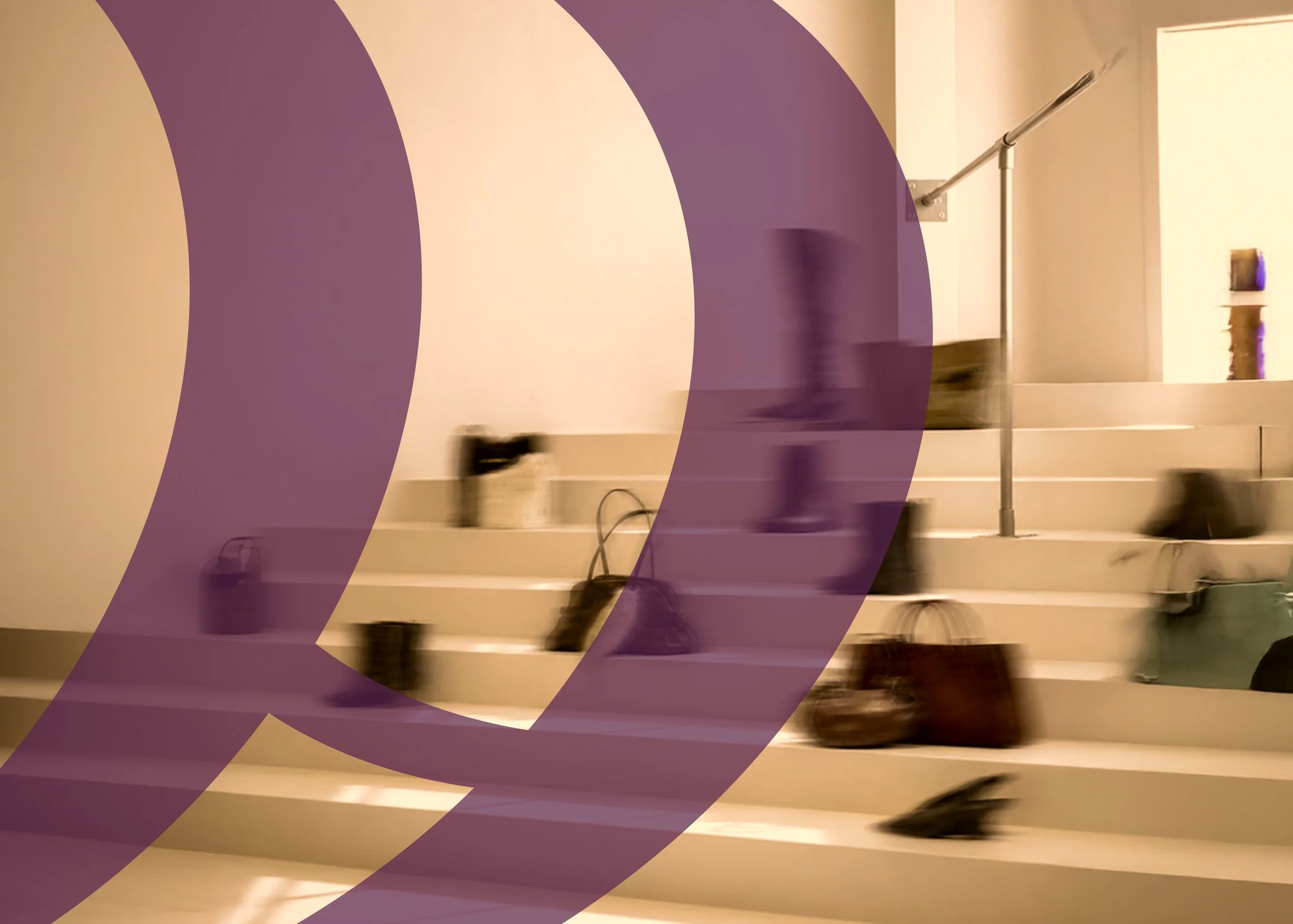 Indoor staircase with a handrail on the right side, shoes placed on the steps, and purple objects on display on the wall.