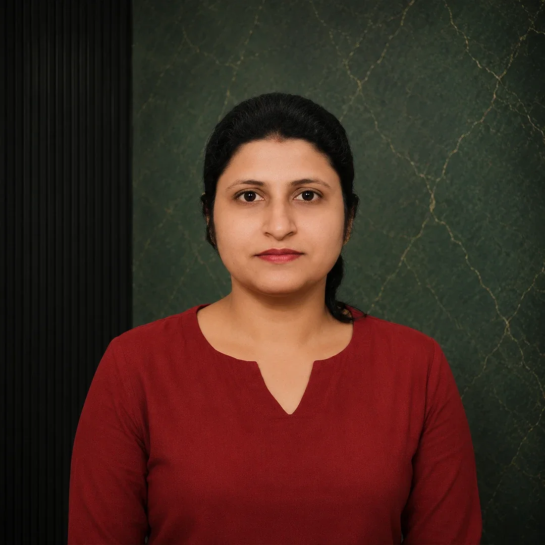 A woman with dark hair in a red top standing against a green textured background.