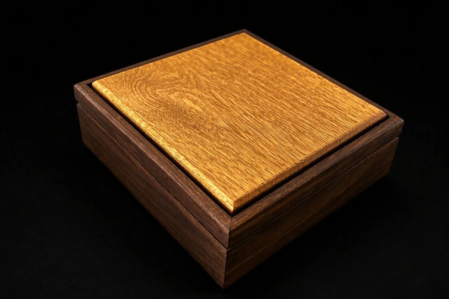 A wooden box with a polished, golden-brown top and darker brown sides, placed on a black background.