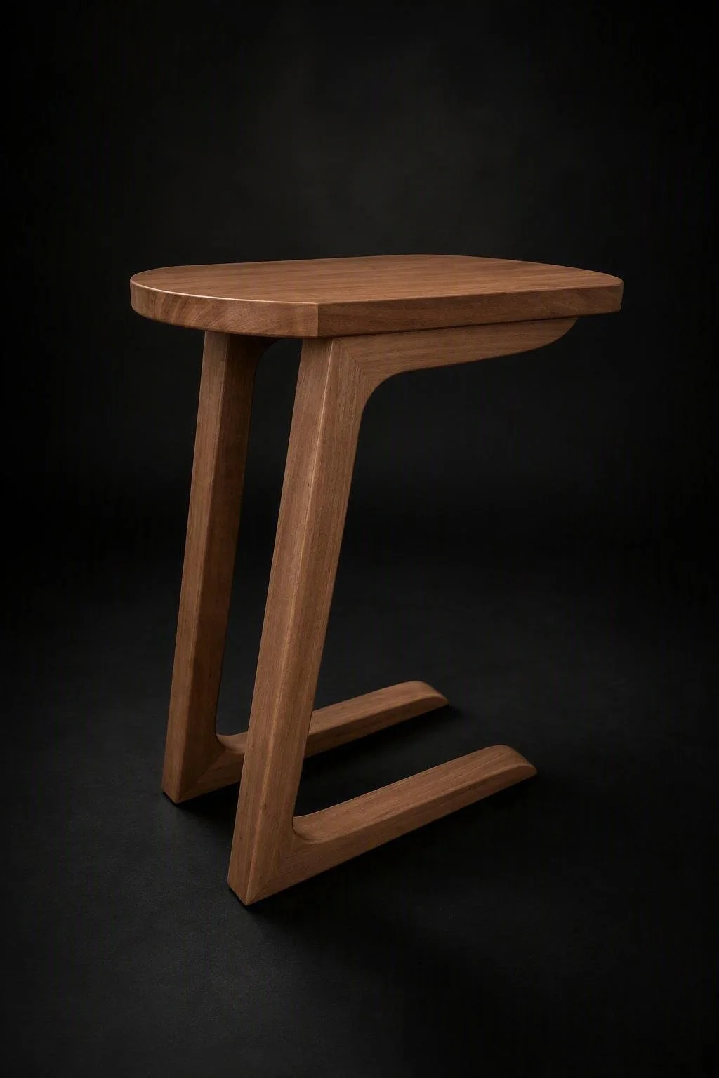 A modern wooden side table with a rounded top and curved legs, set against a black background.