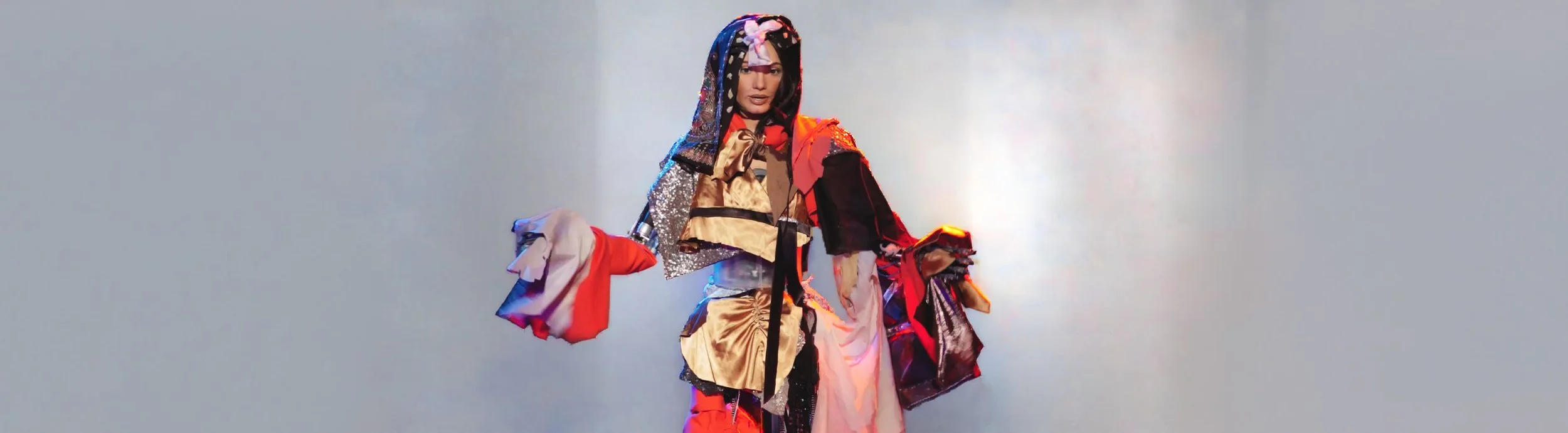 人形机器人 Ai-Da 在舞台上穿着多彩拼接服装进行表演