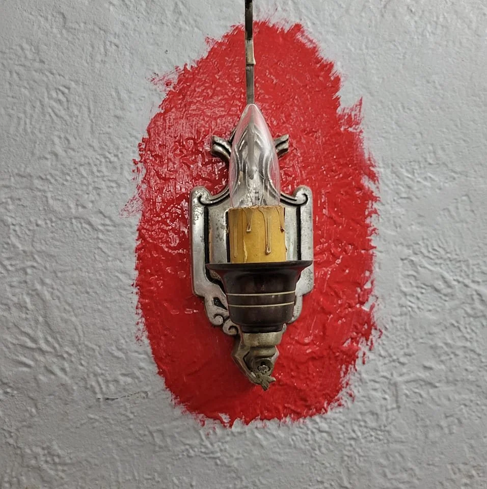 Antique living room gas light fixture without the shade, converted to electricity and  at the start of painting a light grey living room red.
