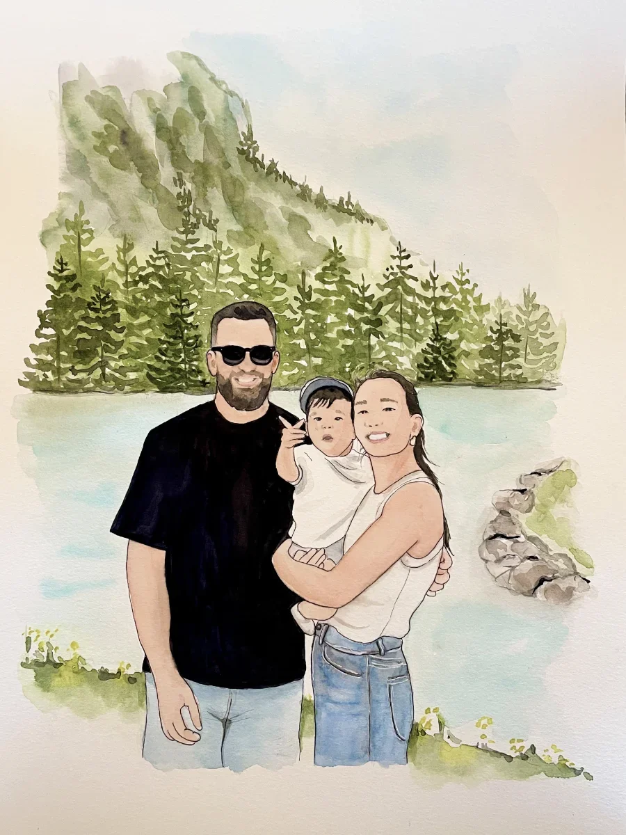Une famille pose près d'un lac entouré d'arbres et de montagnes. Le père porte des lunettes noires et un t-shirt noir, la mère porte une chemise blanche et tient un enfant dans ses bras, tous sourient.