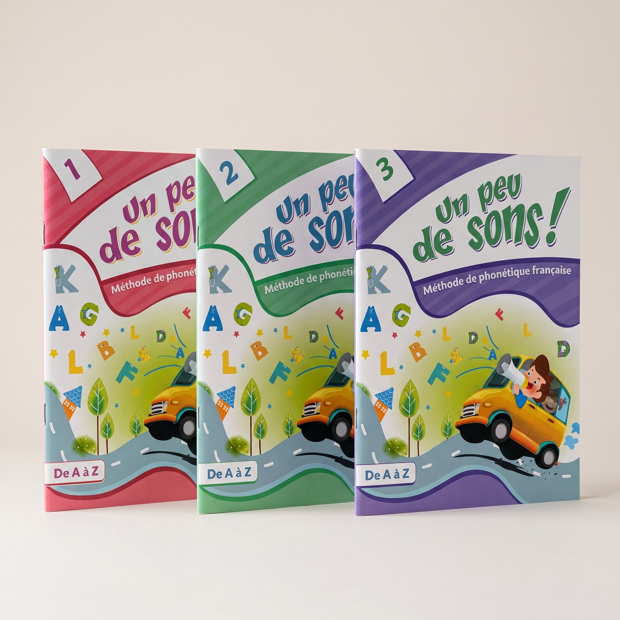 Three colorful educational booklets titled 'Un peu de son', each with different color schemes: red, green, and purple, featuring playful illustrations of animals, vehicles, and children, set against a plain, neutral background.