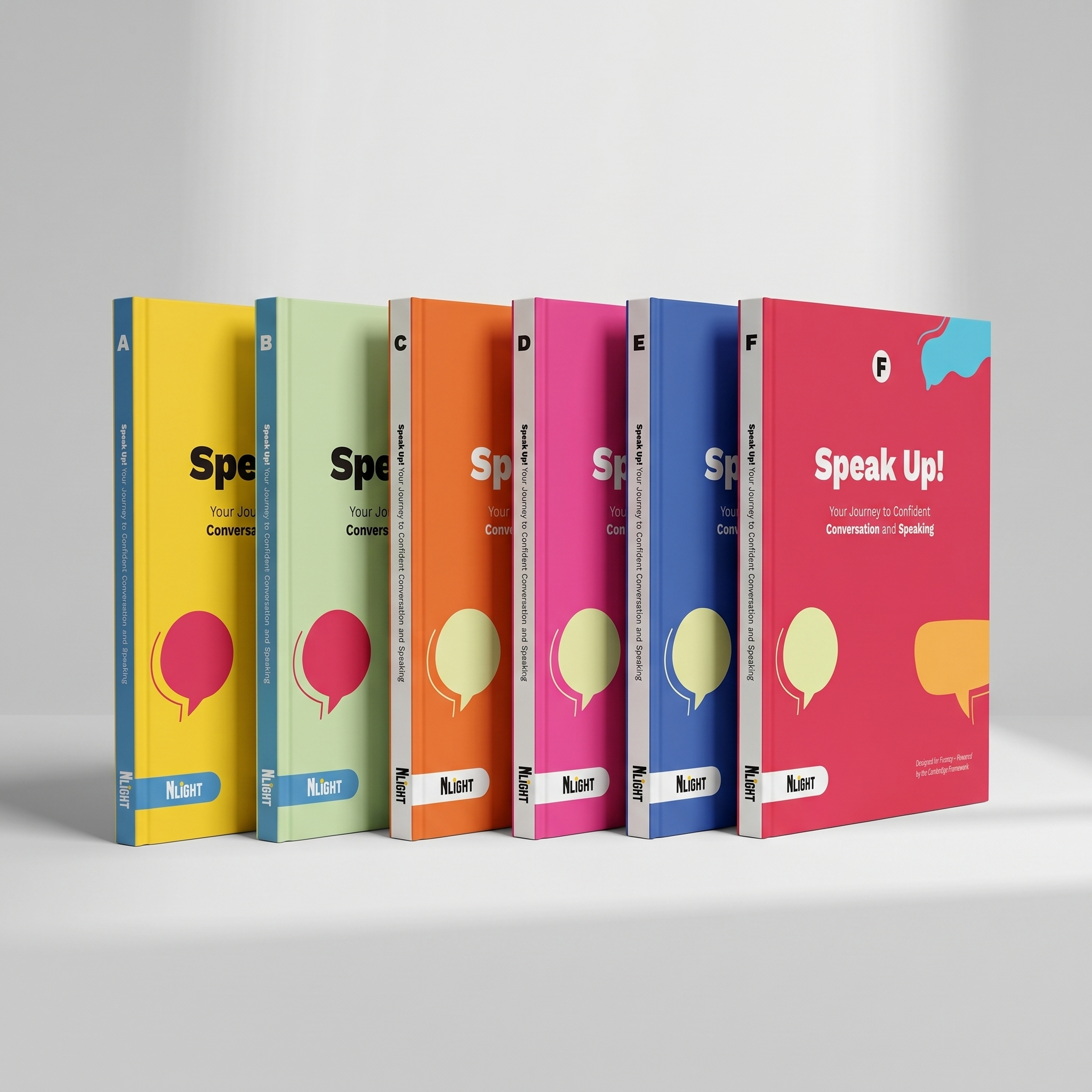A row of seven colorful books placed upright on a white surface against a plain grey background. The books are in yellow, green, orange, pink, blue, navy, and red colors, with the words 'Speak Up! Your Journey to Confident Conversation and Speaking' visible on some of the spines.