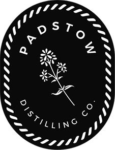 Logo for Padstow Distilling Company featuring a flower illustration and text encased in a dotted oval border.