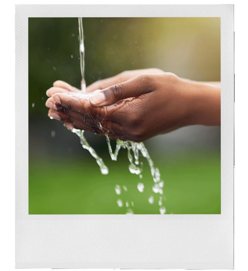 Hands cupping water, with water dripping from fingers and flowing over palms.