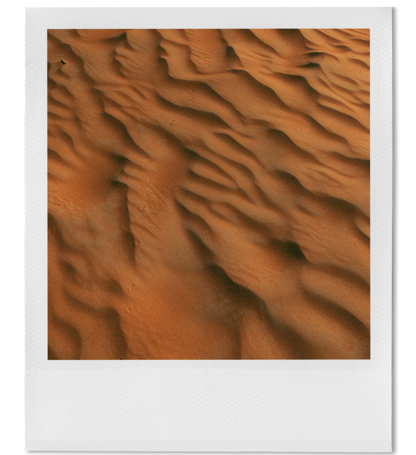 Close-up of sand dunes with rippled patterns in a desert landscape.