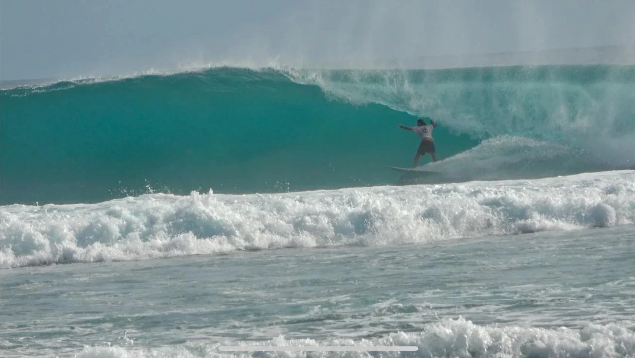 Surfista che sta cavalcando un'onda grande in mare.