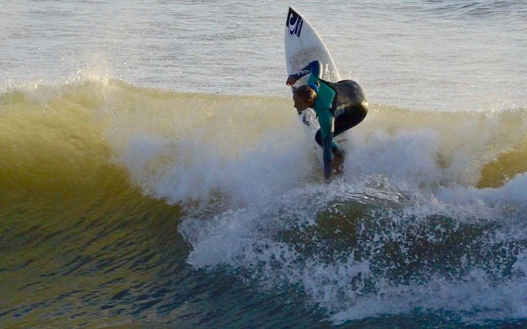 Surfista che esegue una manovra su un'onda in mare