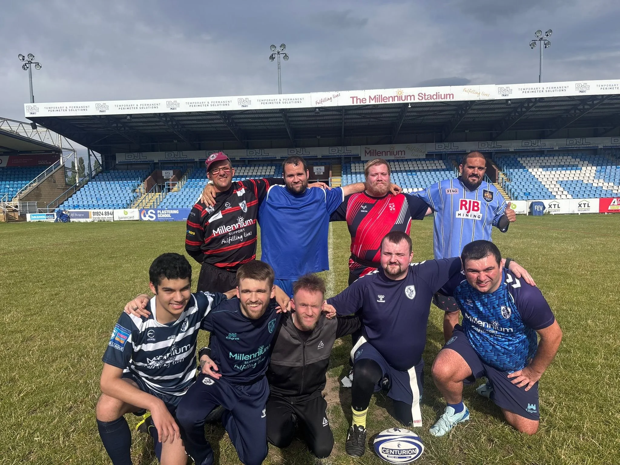 A group of young men with learning disabilities huddled together in their rugby kits