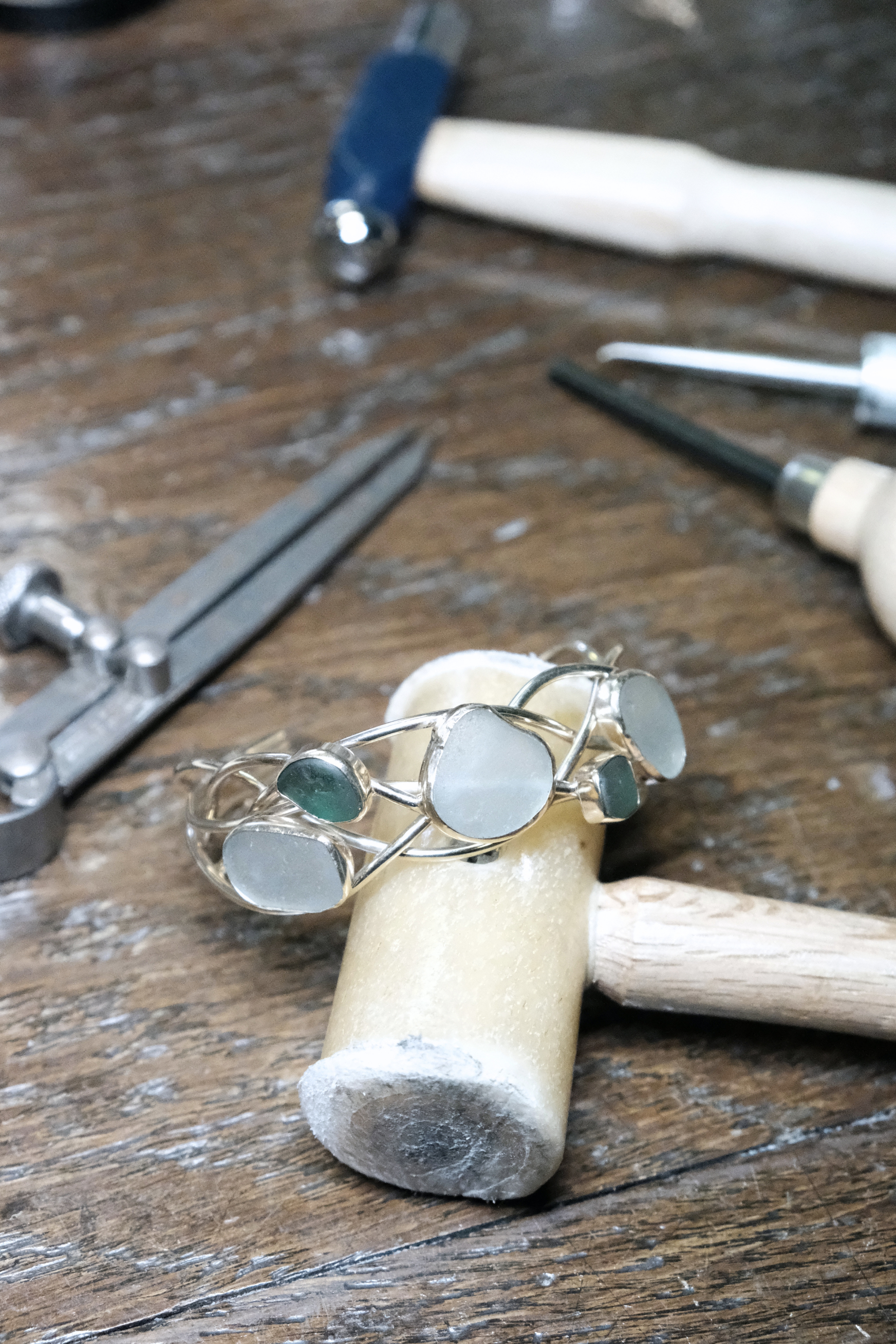 Close-up of orthopedic tools and a metal ring with mirrors resting on a wooden surface.