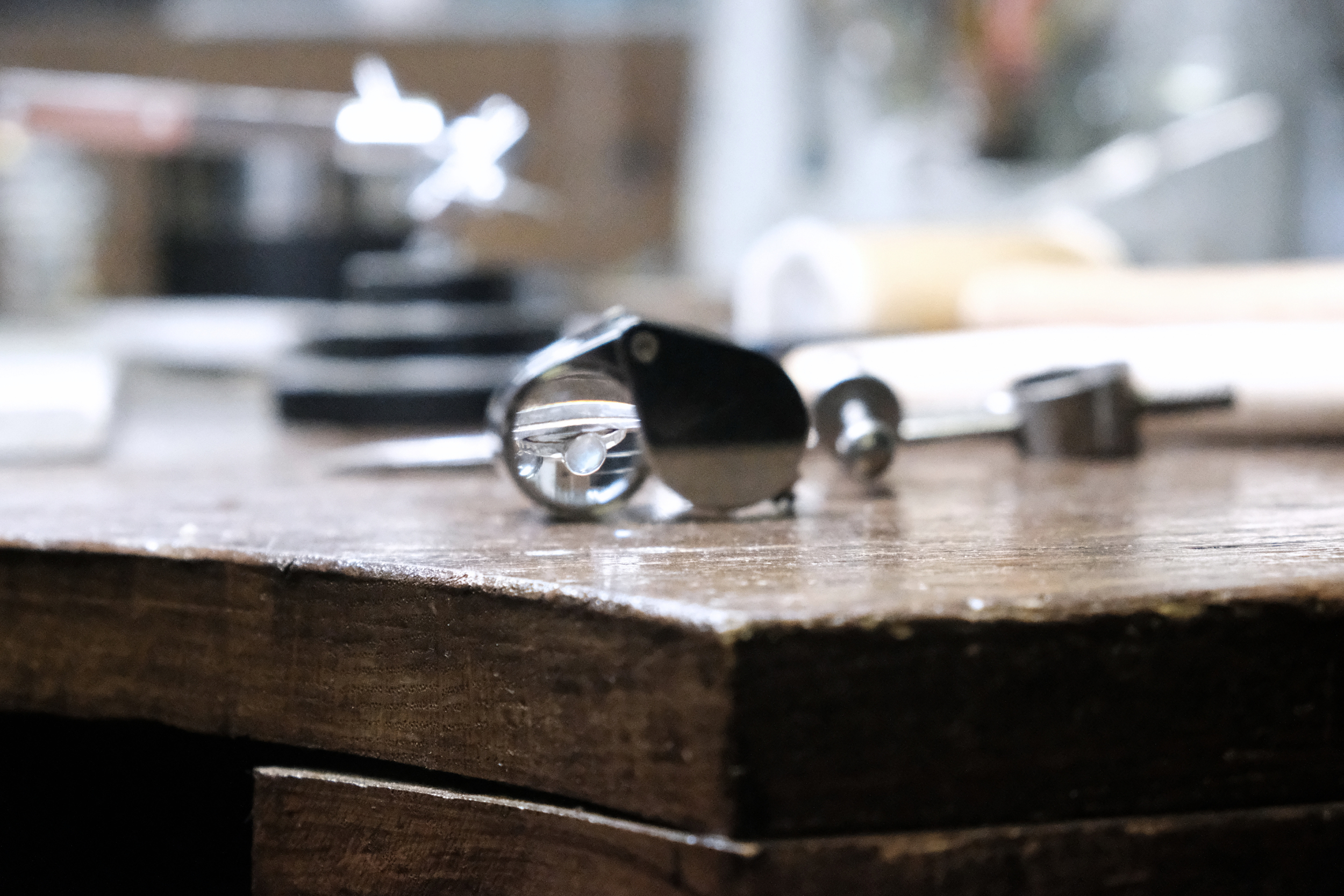 Close-up of a metal nut and bolt on a wooden surface, with a blurred background.