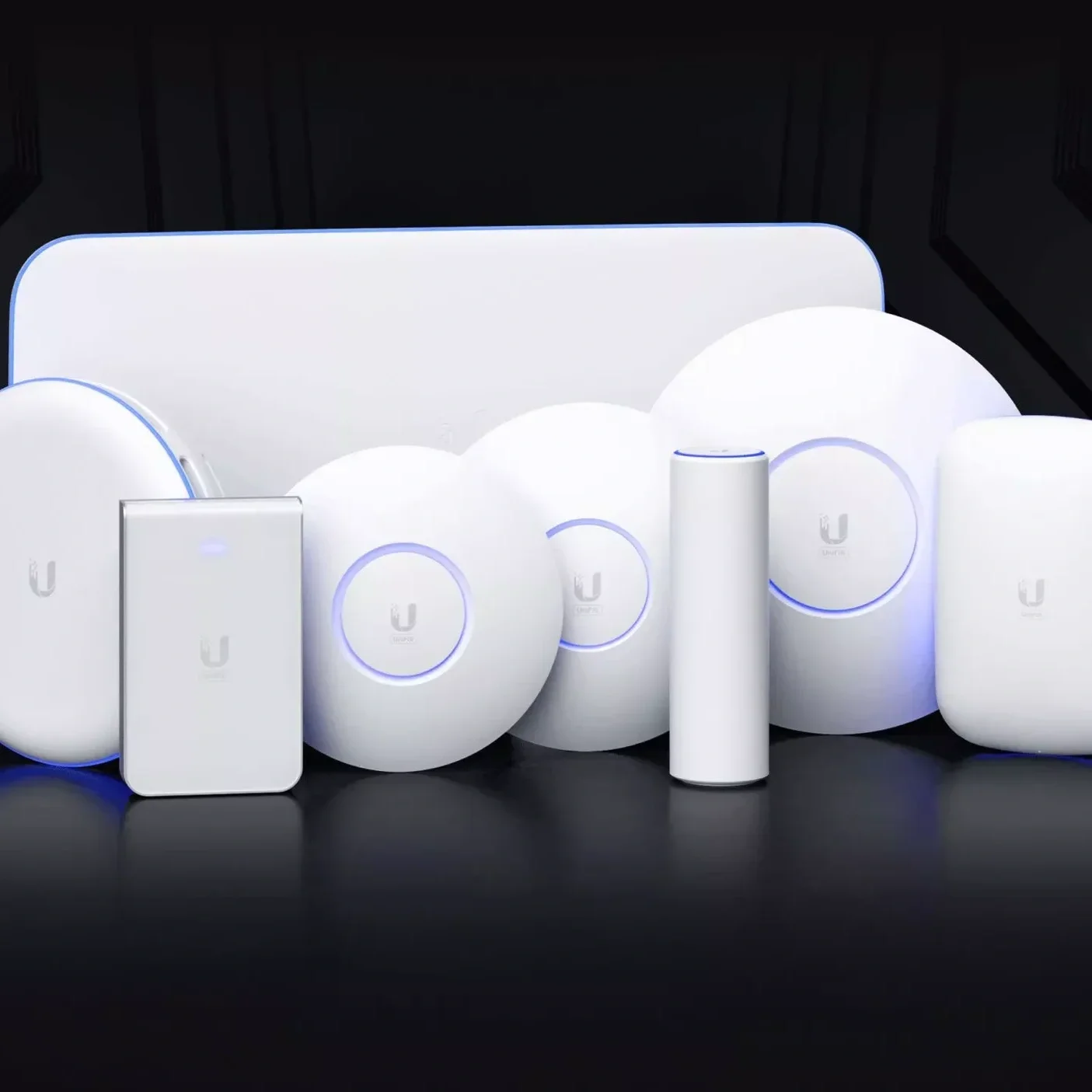 Een verzameling van witte elektronische apparaten en componenten, inclusief een smartphone, een ronde apparaten met blauwe ringen, en cilindrische en vierkante apparaten, allemaal met het 'U' logo.