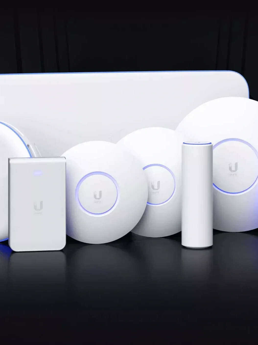 Een verzameling van witte netwerkkachels en een router, allemaal met blauwe LED-verlichting, geplaatst voor een donkere achtergrond.