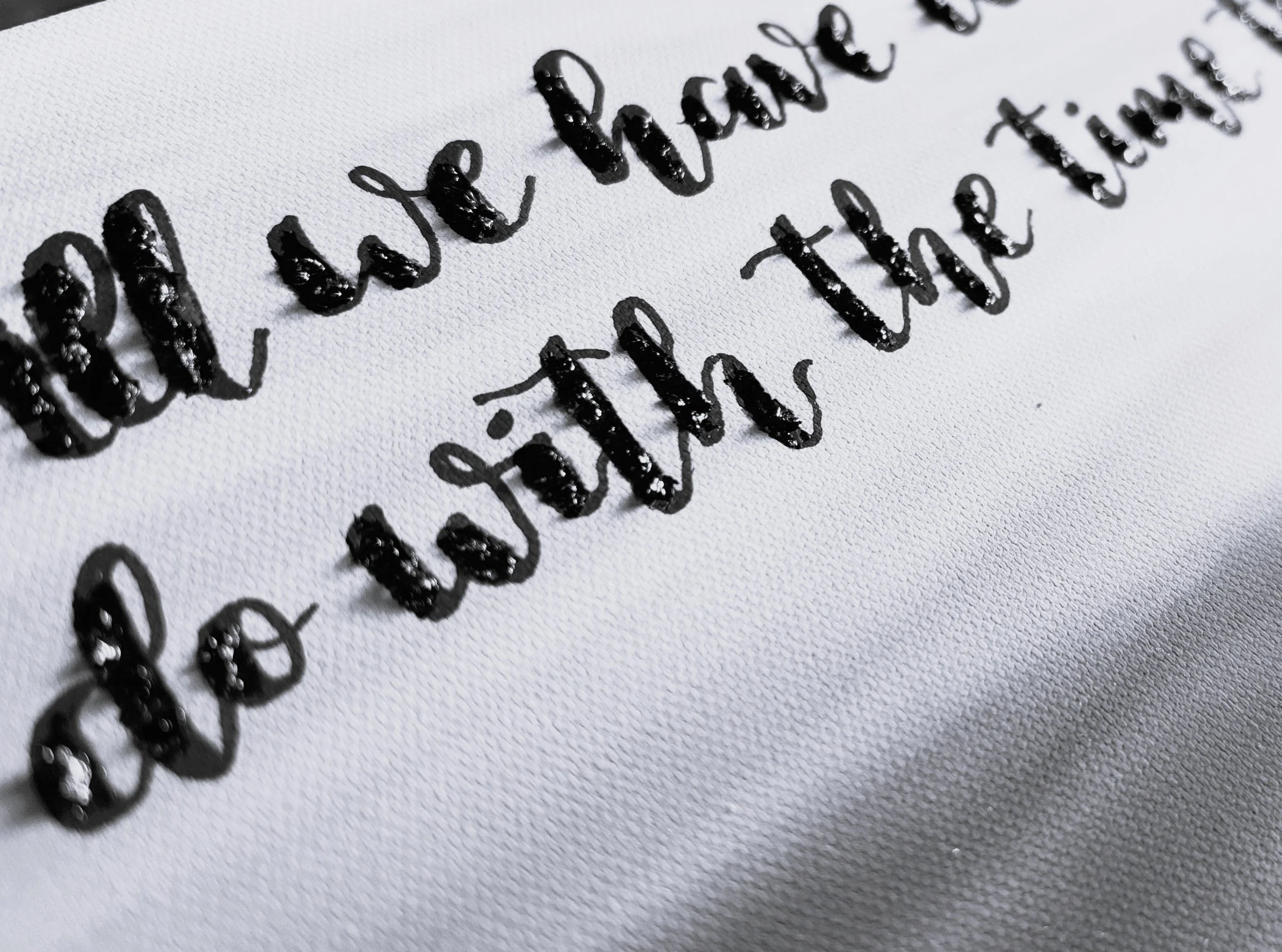 Close-up of handwritten text on white paper with black ink, showing the words 'hello world' written in cursive.