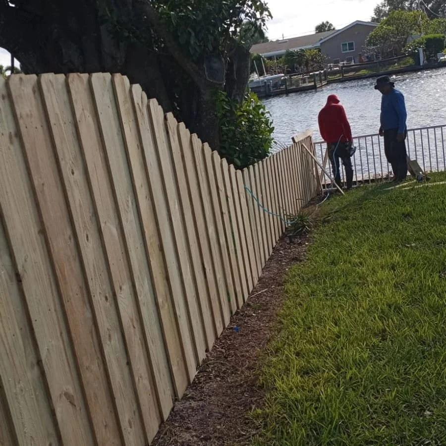 Fence Market crew installing wood picket fence at waterfront property in Florida