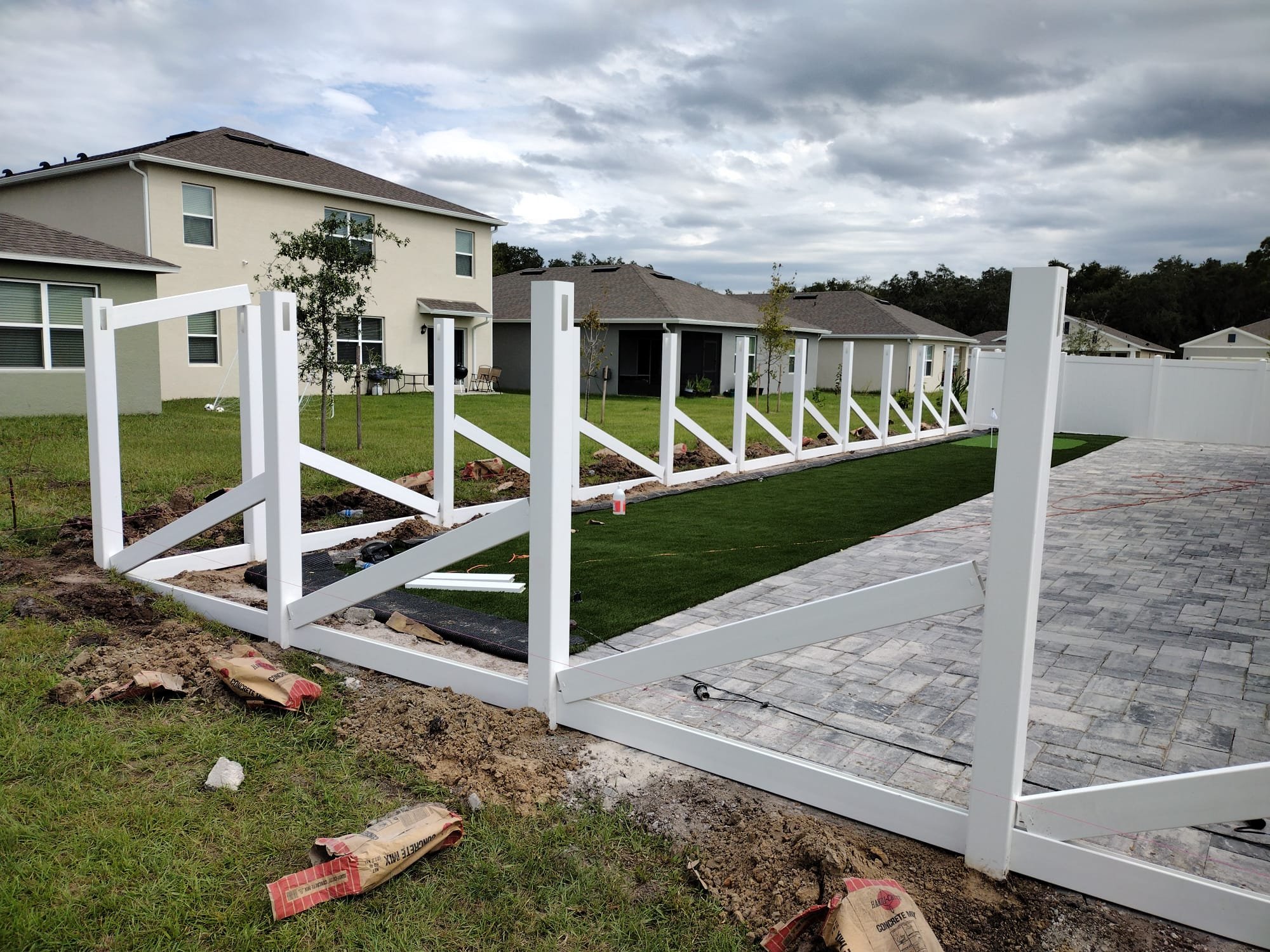 White vinyl ranch fence with horizontal rails installed at Florida home