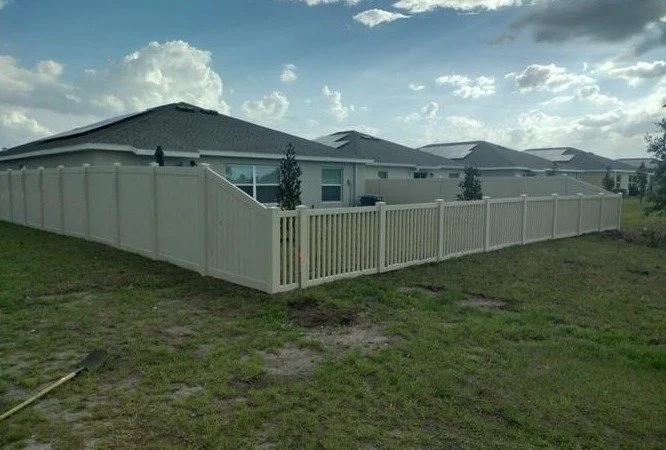 Tan vinyl privacy fence with matching picket section in Central Florida