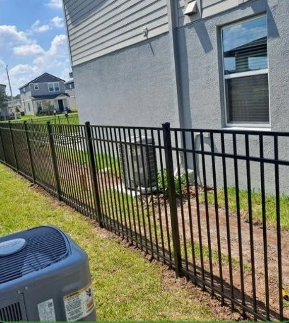Black aluminum fence installed beside a Central Florida home