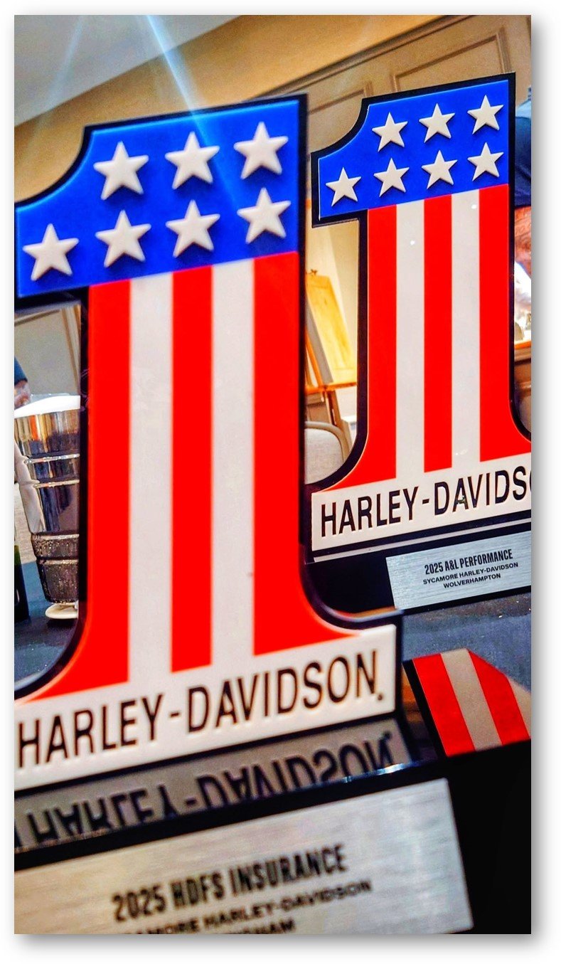 Harley-Davidson logo with American flag design, displayed on a table at an event.