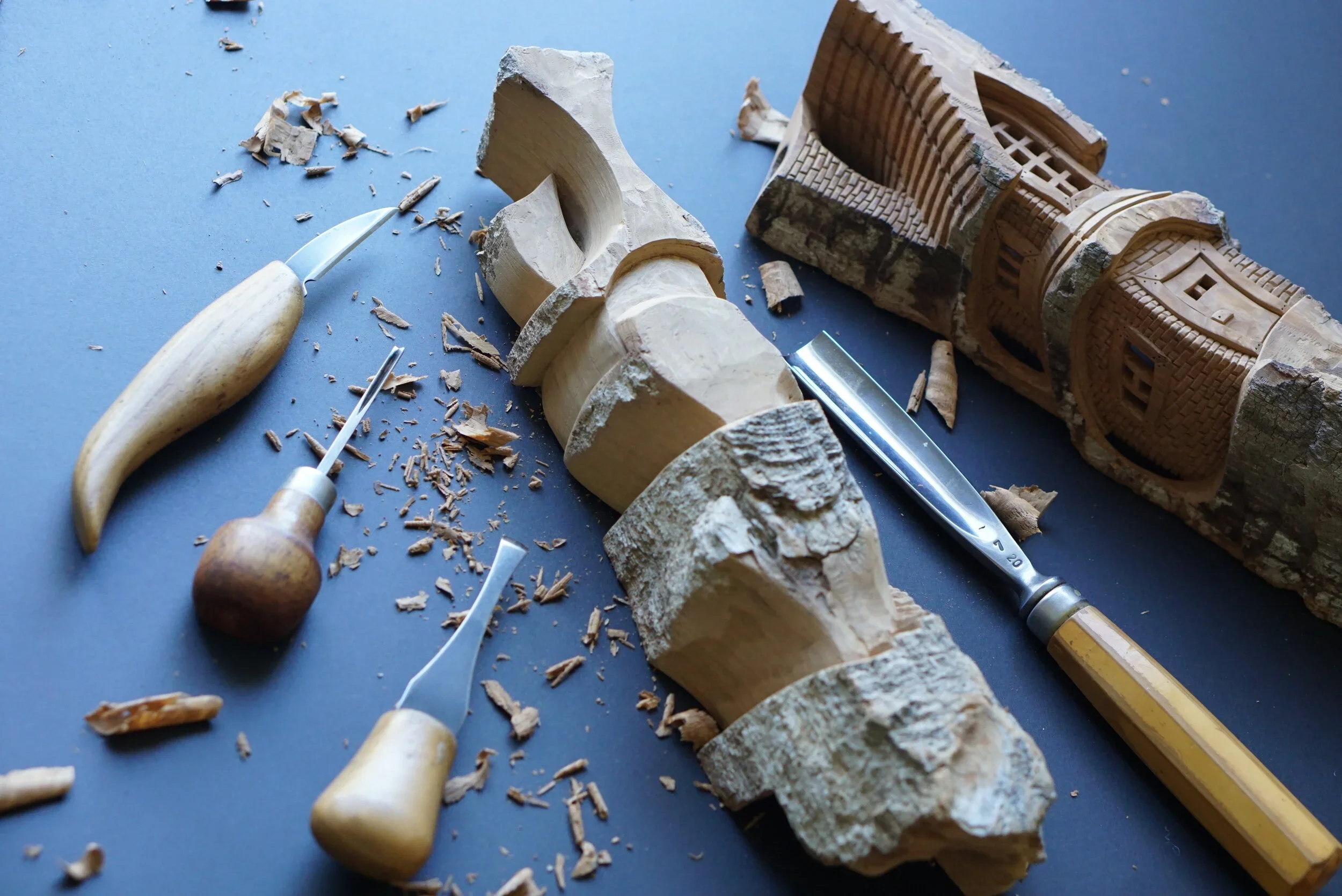 wood carving tools and partially carved house