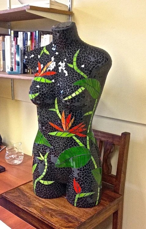 mannequin covered in glass mosaic with a bird of paradise pattern