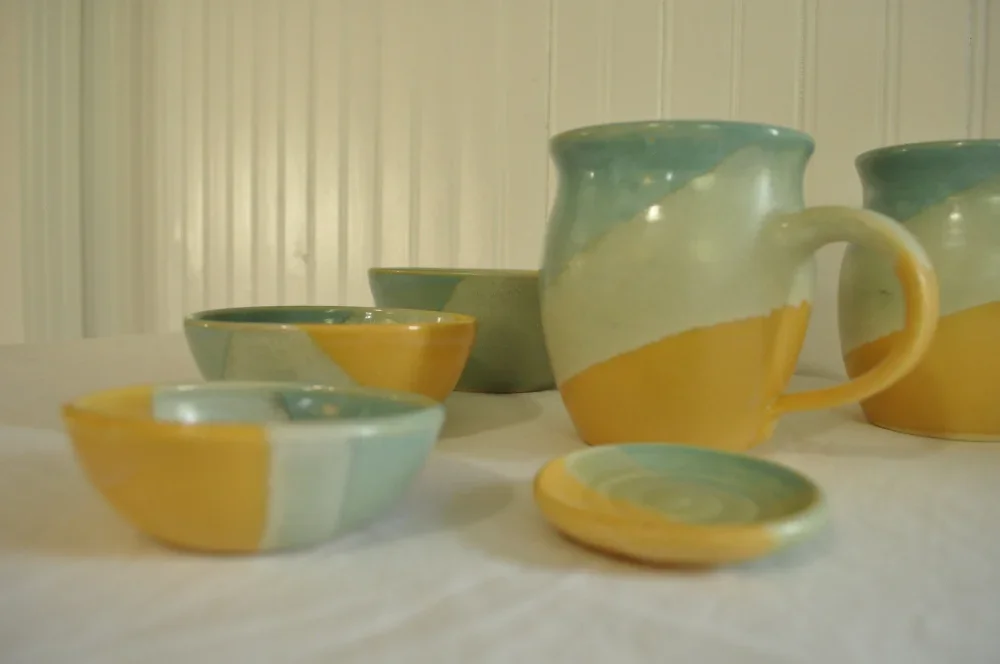 yellow and green pottery bowls, mugs