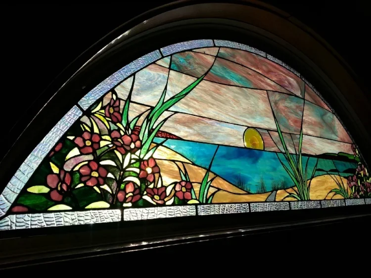 framed glass curved panel of flowers by the sea at sunrise/sunset