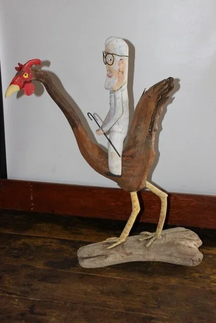 driftwood art of man riding a chicken 