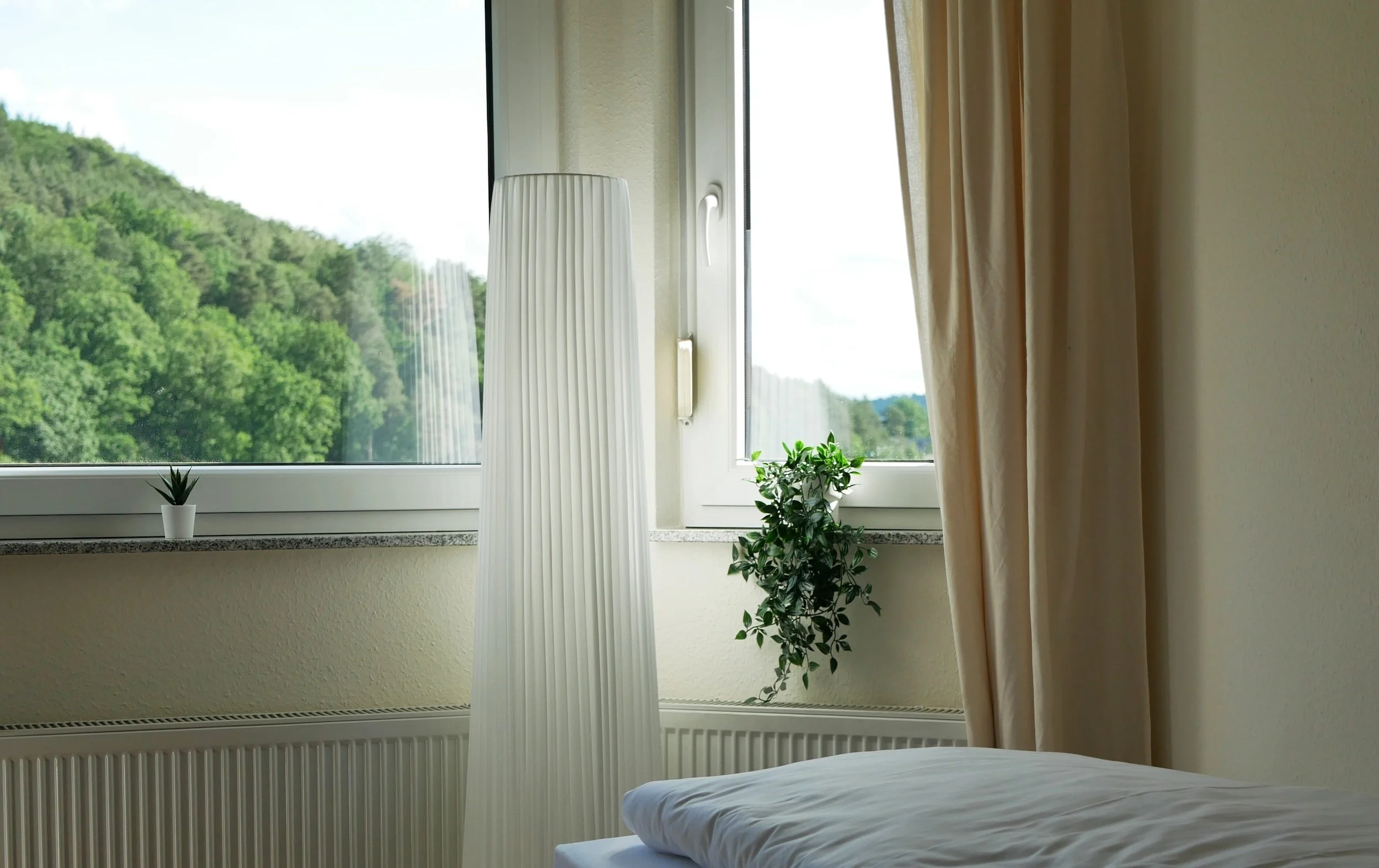 Ausblick auf einen bewaldeten Berg aus einem Zimmer in Haus 2