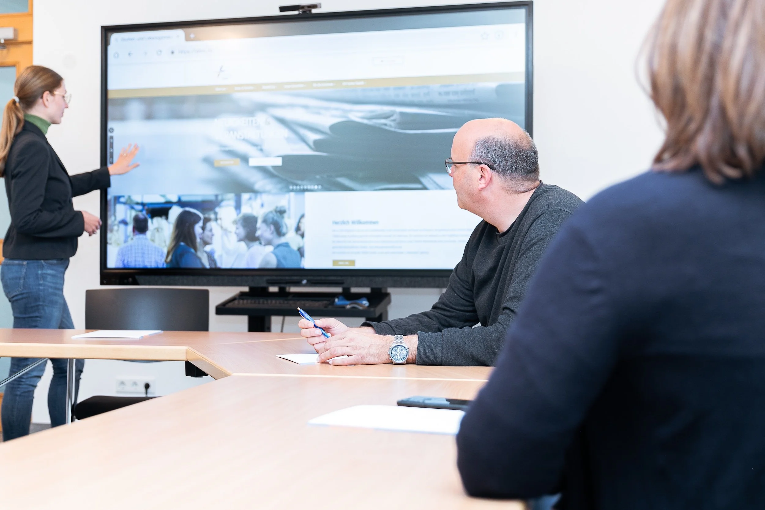 Person erklärt etwas am Smartboard