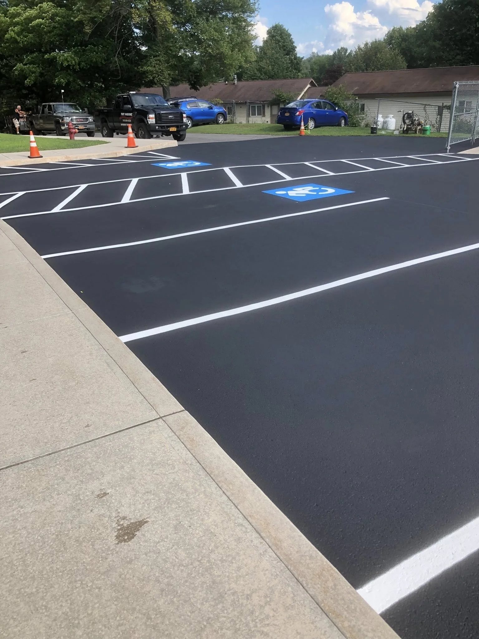 Newly painted parking lot with designated accessible parking spaces marked with blue wheelchair symbols.