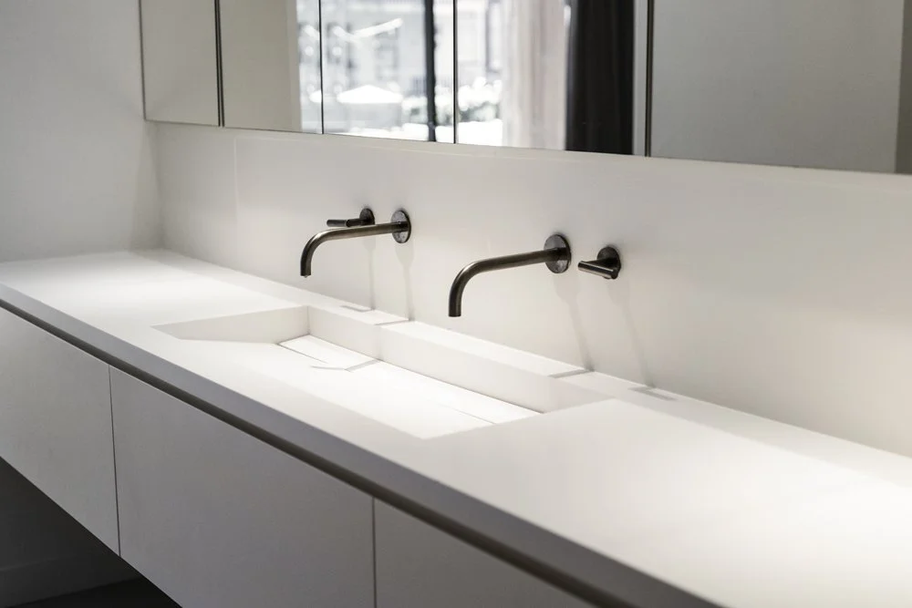 Minimal double bathroom vanity with wall-mounted black faucets in a De Pijp apartment
