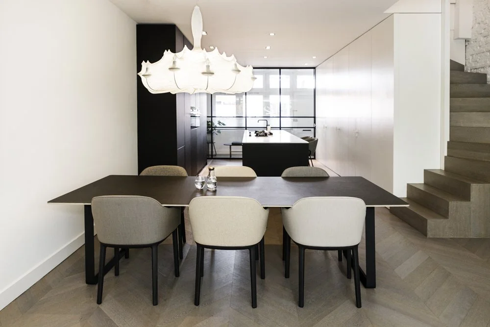 Open-plan dining and kitchen interior with bespoke cabinetry and staircase in De Pijp, Amsterdam