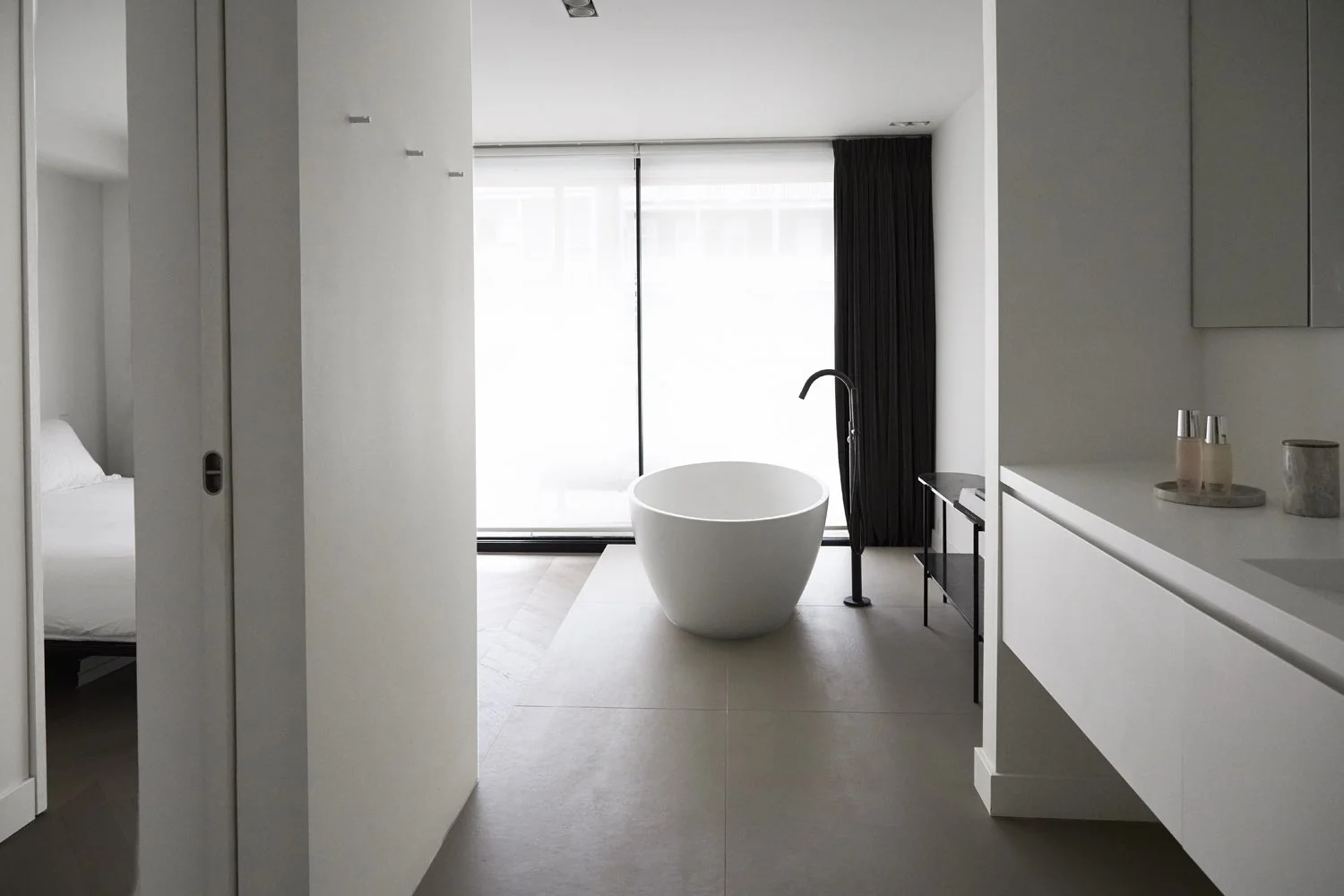 Open-plan apartment interior leading to a freestanding bathtub in De Pijp, Amsterdam