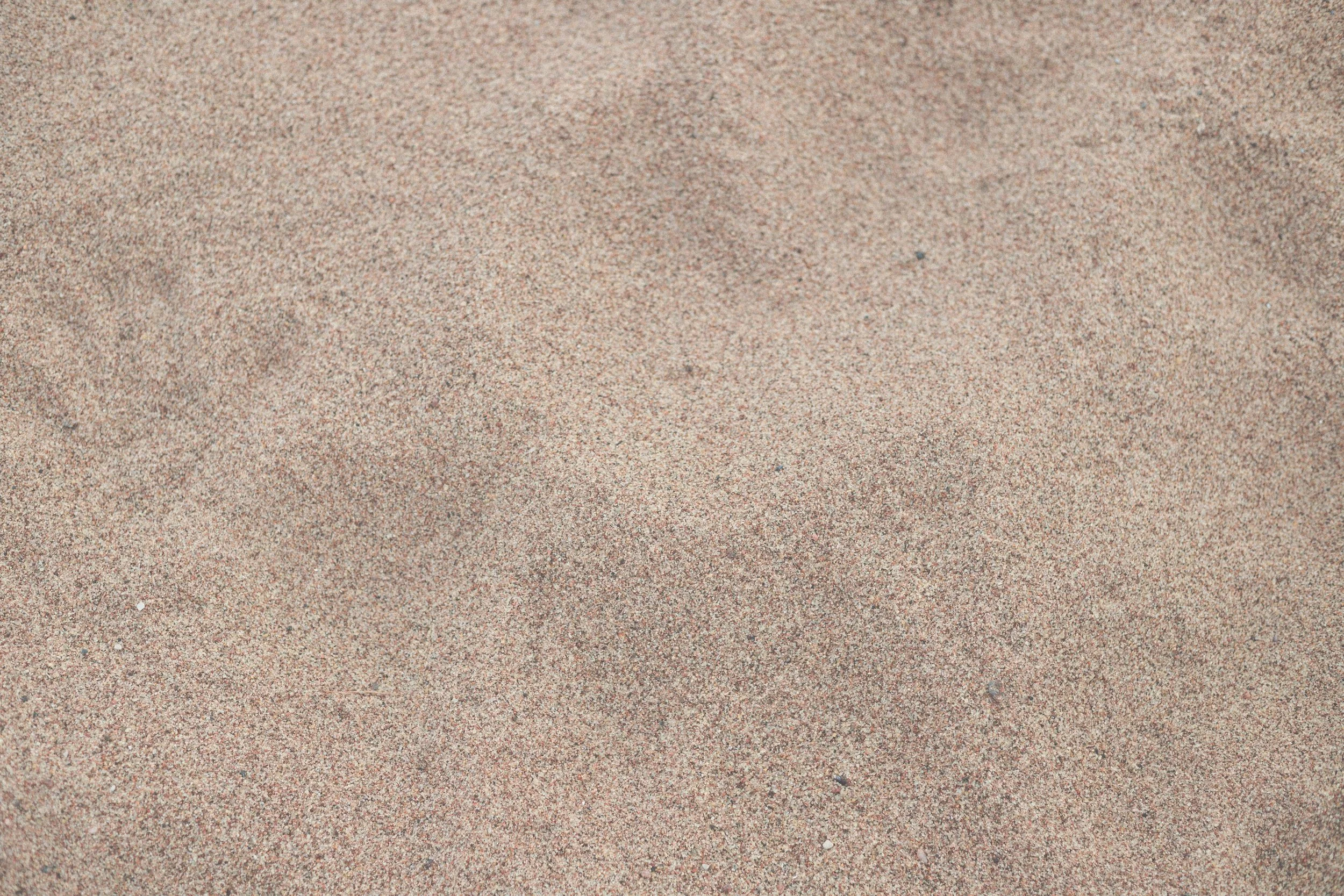 Close-up of fine sand with small grains of sand, no objects or people visible.