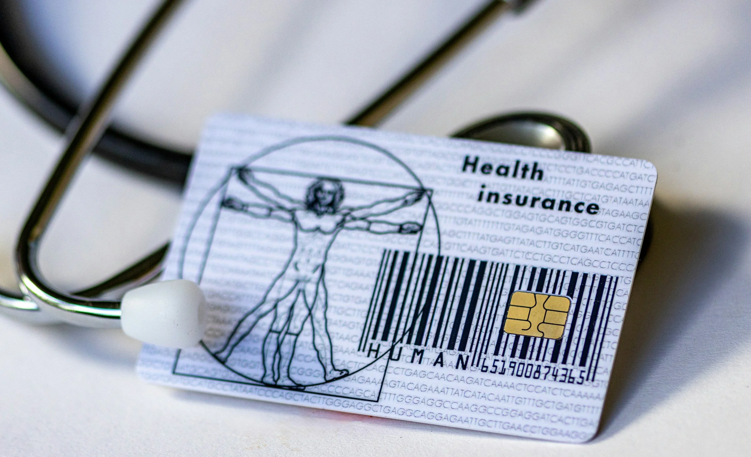 Stethoscope, social security card with health insurance logo, barcode, and medical information, and white earbud wires.