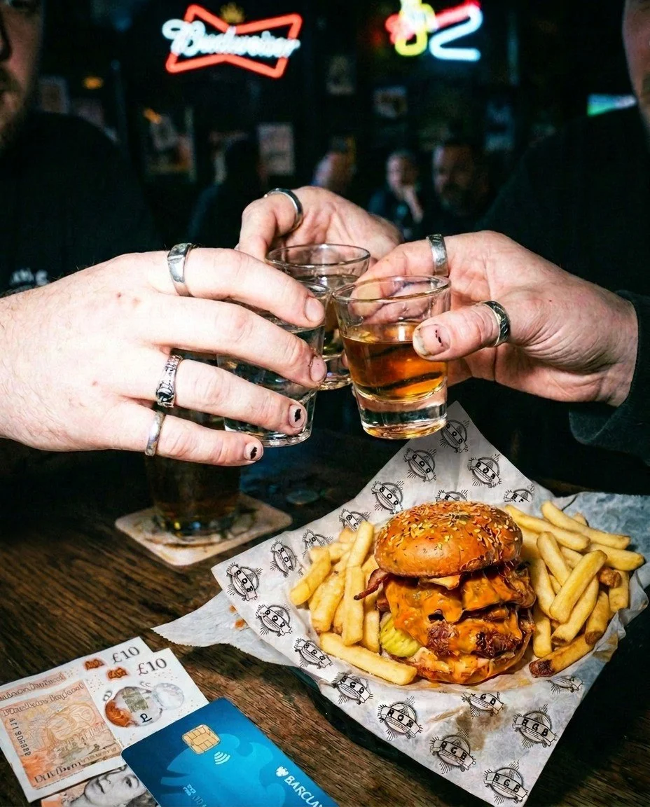 People cheersing a round of shots with a burgers and chips on the table