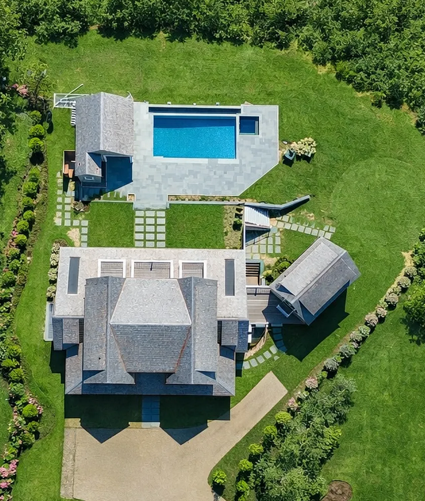 Aerial view of the property, showing the main house, detached carriage house, separate pool house, and bluestone pool aligned across the rear of the lot.