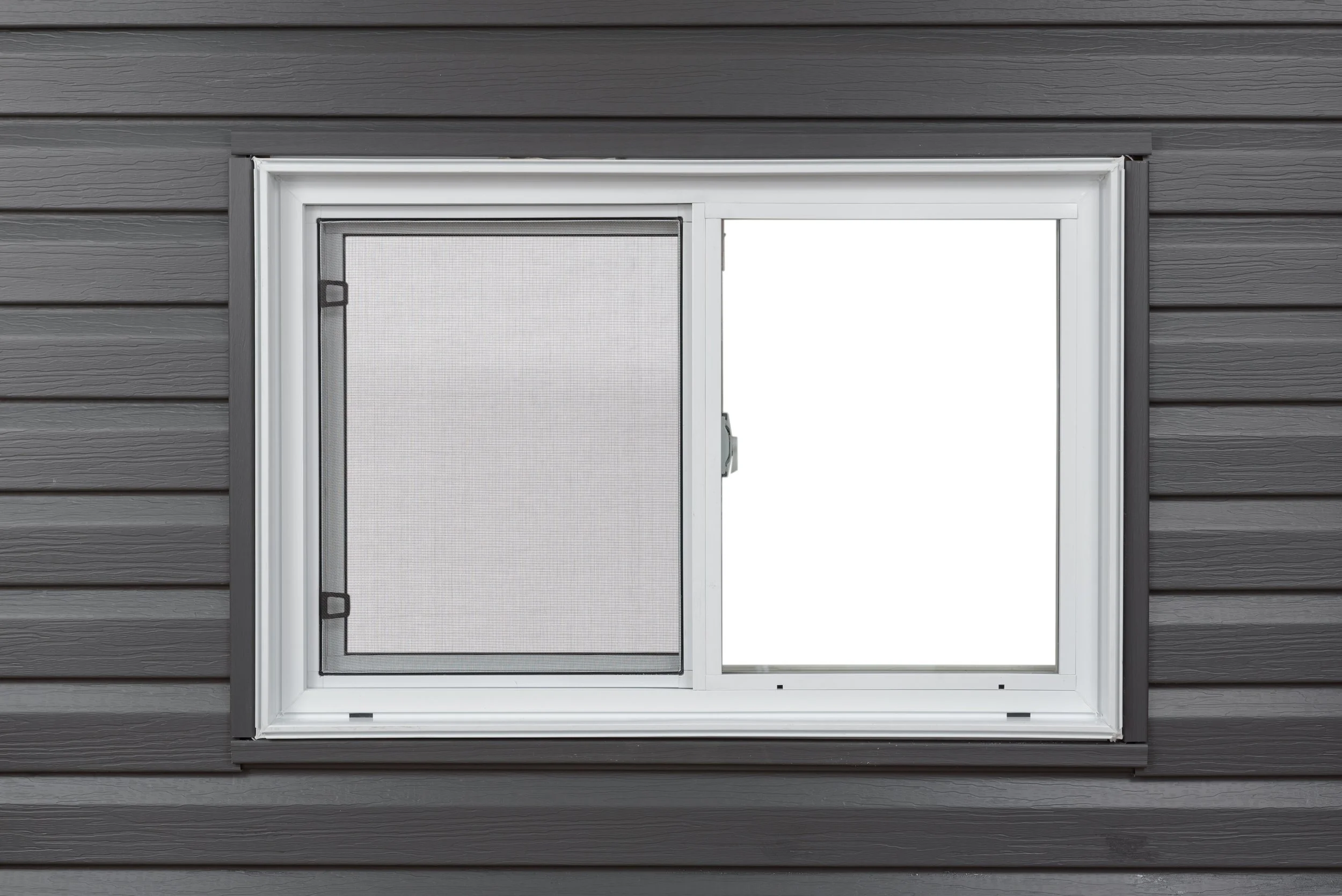 A white window with a black insect screen on a gray wooden wall.