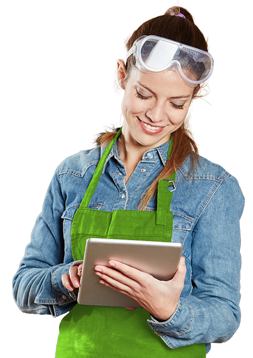 Junge Frau mit Schutzbrille und grünem Kochschürze, die auf ein Tablet blickt, gegen schwarzen Hintergrund.