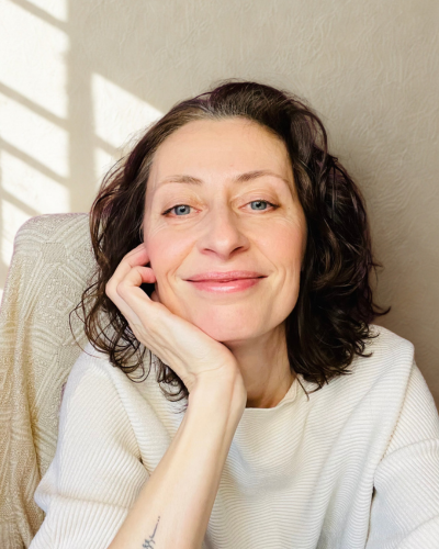 Portrait de Kasia Sakowicz, thérapeute en Intelligence Relationnelle à Paris, souriante et accueillante dans un cadre lumineux.