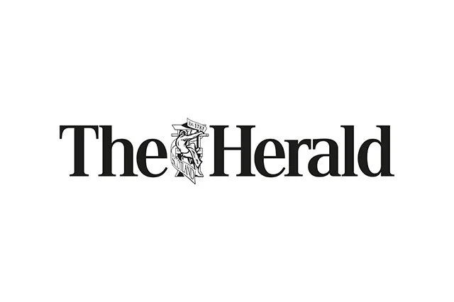 The logo of The Herald newspaper, featuring black text with an illustration of a woman holding a flag between the words 'The' and 'Herald'.