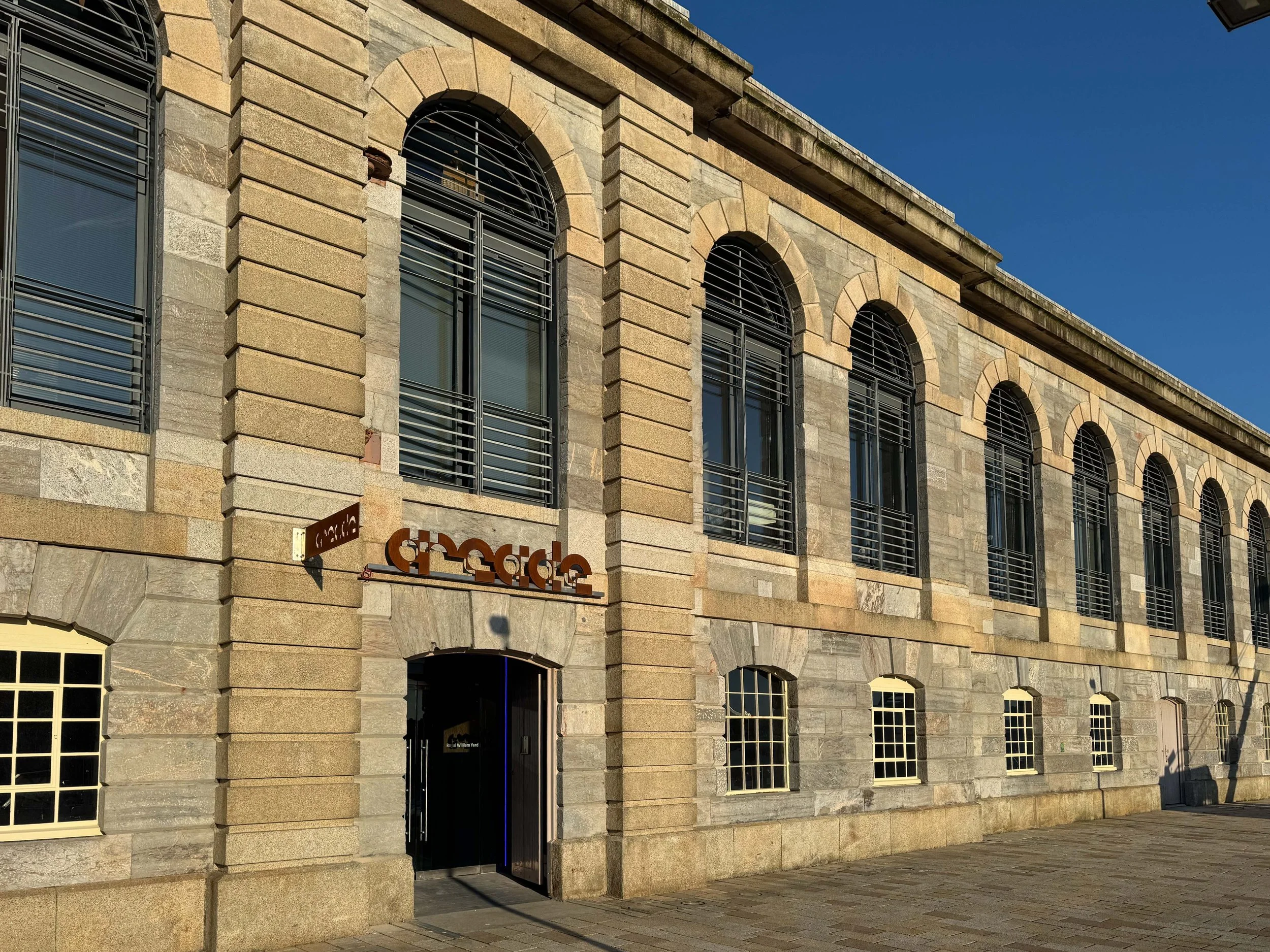 Front view of Arcade building at Royal William Yard, a stone building with arched windows.