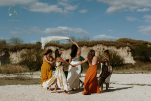 Women enjoying a wellbeing retreat experience on a beach, promoting connection, relaxation and personal growth.