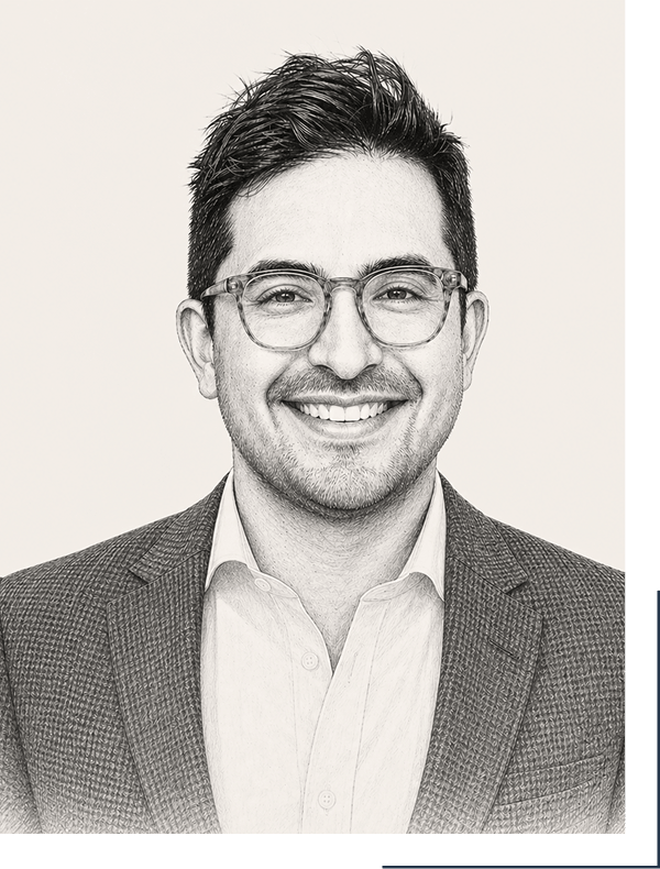 Black and white portrait of a smiling man with glasses, wearing a suit jacket and dress shirt.